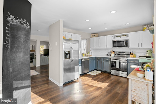 kitchen featuring decorative backsplash, appliances with stainless steel finishes, dark hardwood / wood-style floors, and white cabinetry