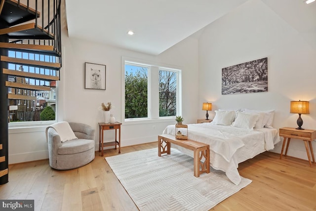 bedroom featuring lofted ceiling and light wood-type flooring