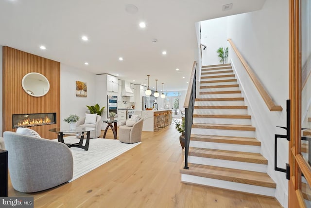 stairway with a fireplace, hardwood / wood-style flooring, and sink