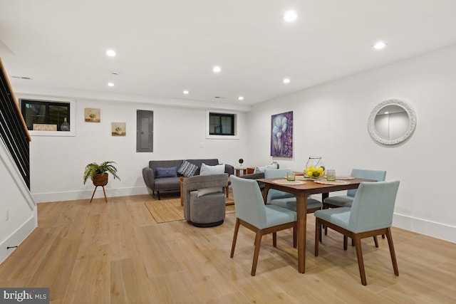 dining area with electric panel and light hardwood / wood-style flooring