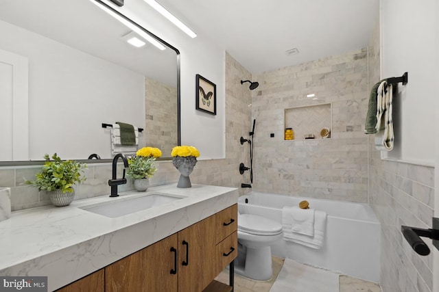 full bathroom featuring vanity, toilet, and tiled shower / bath