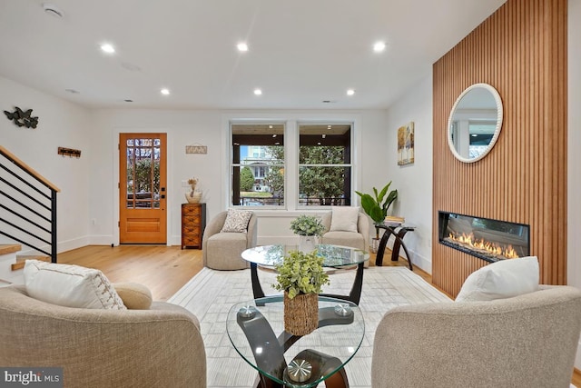 living room with a large fireplace and light hardwood / wood-style floors