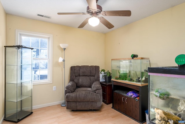 sitting room featuring ceiling fan and light wood-type flooring