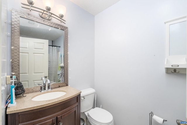 bathroom with vanity, a textured ceiling, and toilet