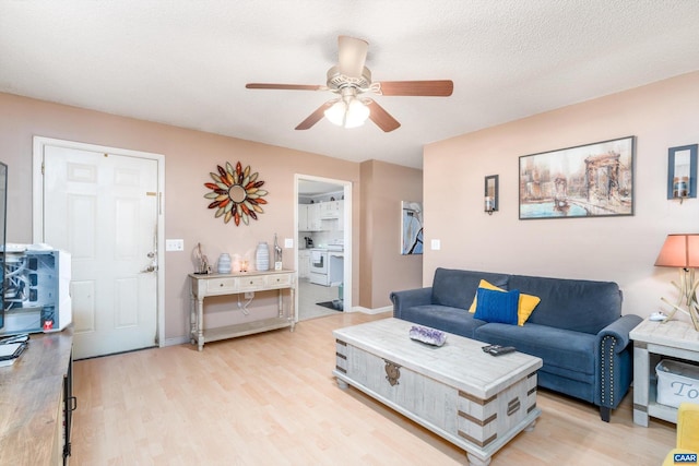 living room featuring a textured ceiling, light hardwood / wood-style flooring, and ceiling fan