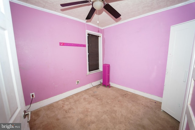 carpeted empty room with ceiling fan and crown molding