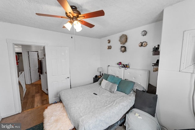 bedroom with wood-type flooring, a textured ceiling, and ceiling fan