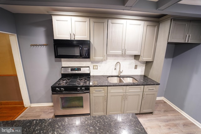 kitchen with sink, light hardwood / wood-style flooring, dark stone countertops, gray cabinets, and stainless steel range with gas cooktop