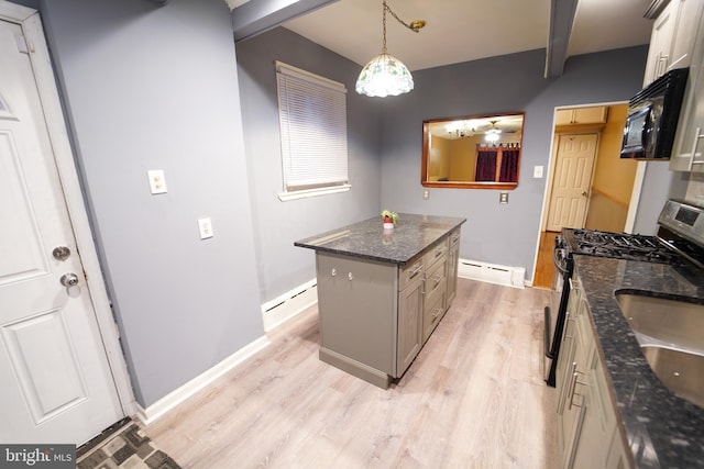 kitchen featuring gas stove, a kitchen island, hanging light fixtures, and baseboard heating