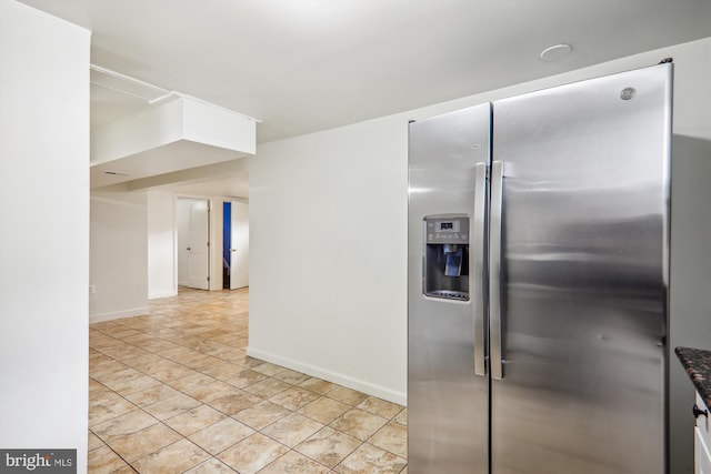 kitchen featuring light tile patterned floors and stainless steel refrigerator with ice dispenser