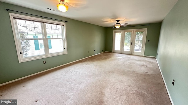 carpeted empty room with french doors and ceiling fan