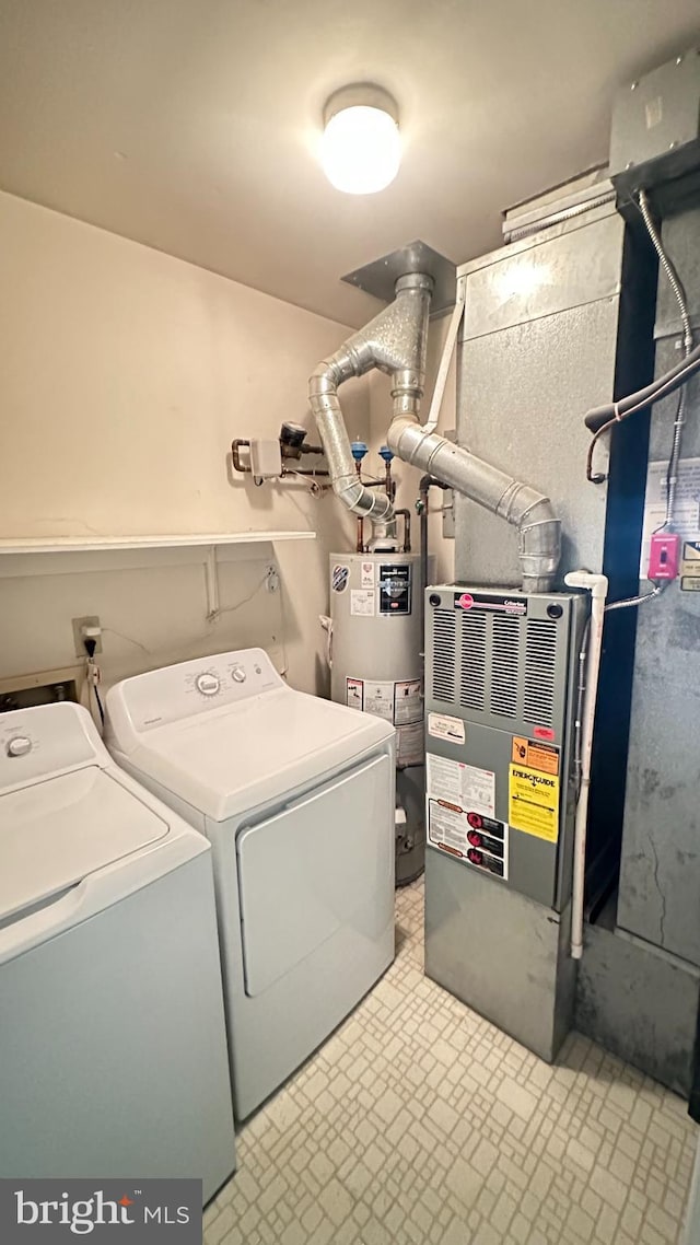 laundry room with water heater and washing machine and clothes dryer