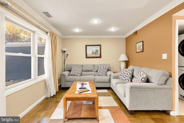 living room with parquet floors, stacked washer / drying machine, and ornamental molding