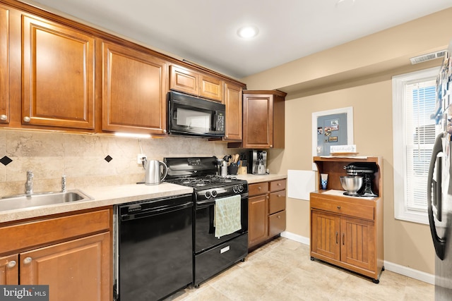 kitchen featuring black appliances, backsplash, and sink