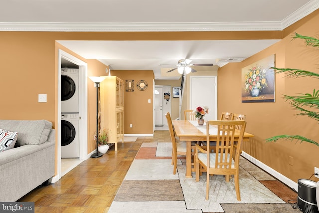 dining room with stacked washer / dryer, crown molding, light parquet floors, and ceiling fan