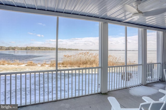 unfurnished sunroom featuring a water view and ceiling fan