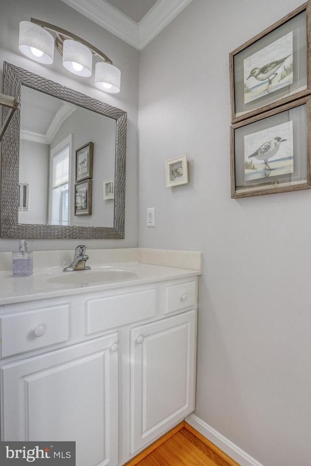 bathroom featuring vanity, crown molding, and hardwood / wood-style floors