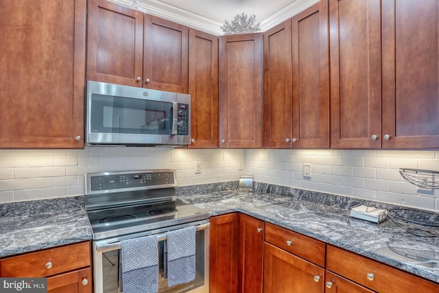 kitchen with appliances with stainless steel finishes, ornamental molding, tasteful backsplash, and dark stone countertops