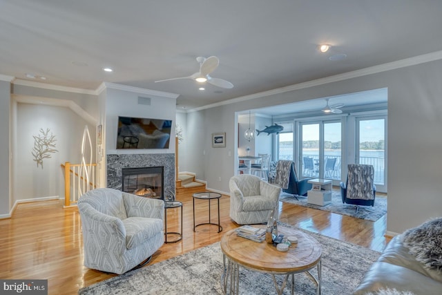 living room with ceiling fan, light hardwood / wood-style flooring, and crown molding