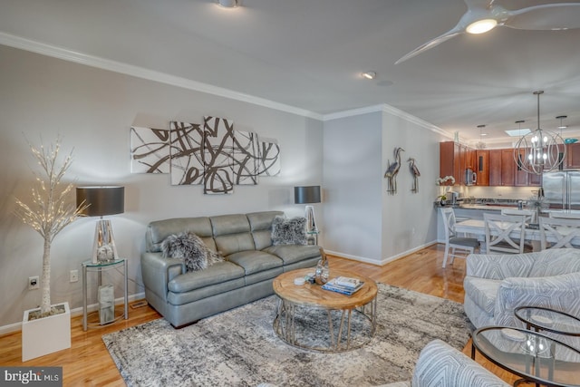 living room featuring light hardwood / wood-style floors, crown molding, and an inviting chandelier