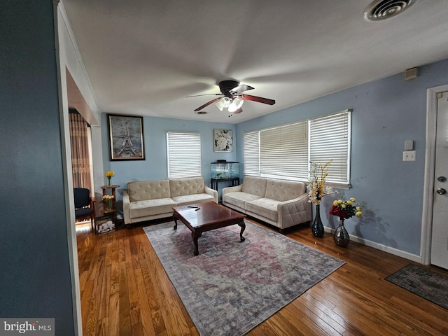 living area featuring a ceiling fan, dark wood finished floors, visible vents, and baseboards