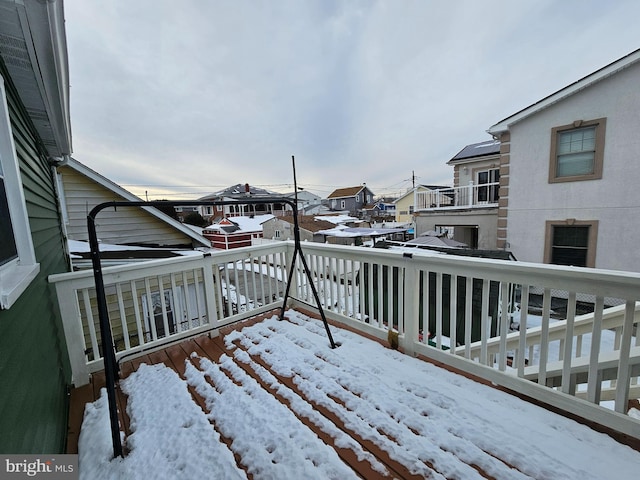 snow covered deck with a residential view