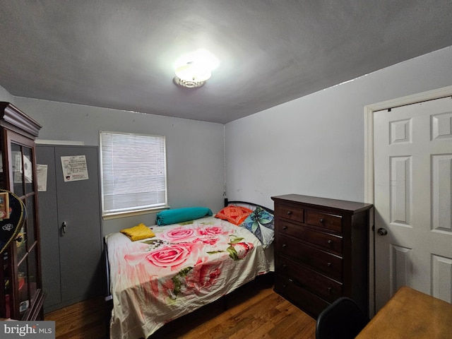 bedroom with dark wood-style flooring