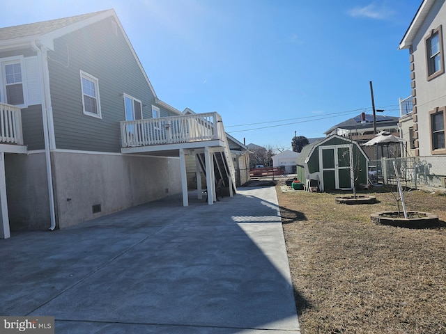 exterior space with a wooden deck, a storage unit, and an outbuilding