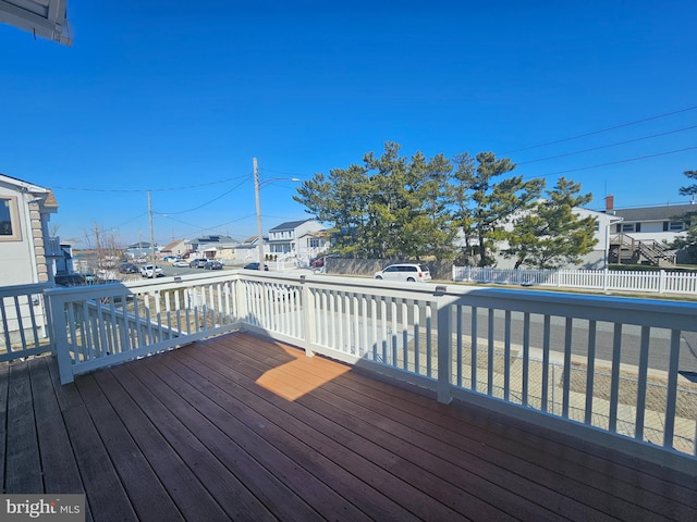 wooden deck with a residential view and fence