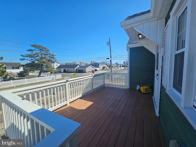 wooden terrace with a residential view and fence