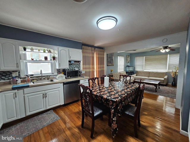 kitchen featuring stainless steel appliances, white cabinets, a sink, and dark wood-style floors