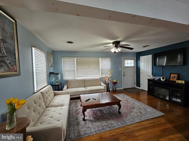 living area with a ceiling fan, dark wood-style flooring, visible vents, and baseboards