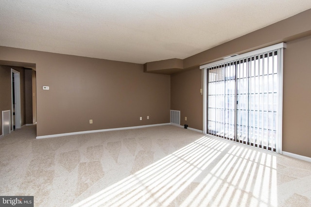 carpeted spare room with a textured ceiling