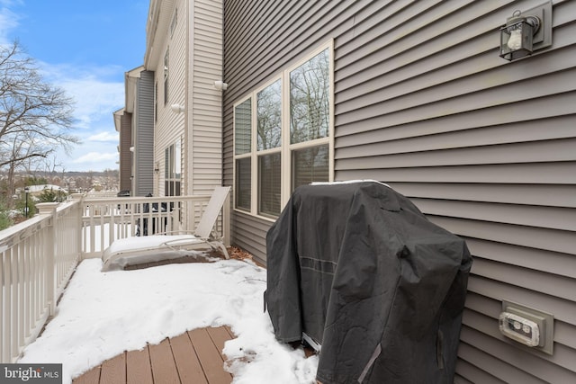 snow covered deck with a grill