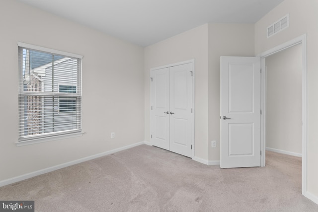 unfurnished bedroom featuring a closet and light carpet