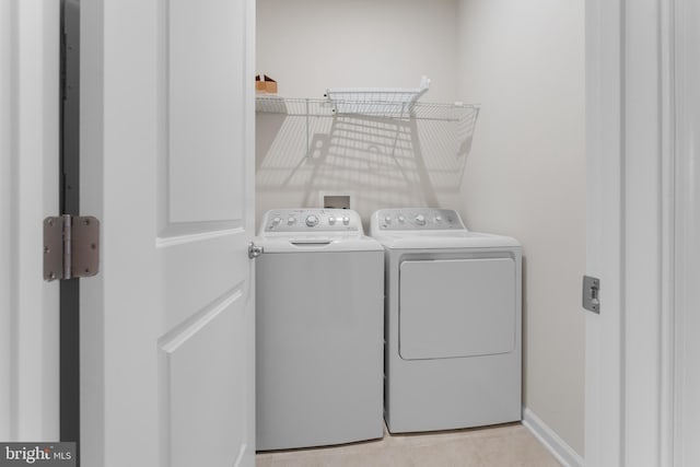 laundry area featuring independent washer and dryer and light tile patterned flooring