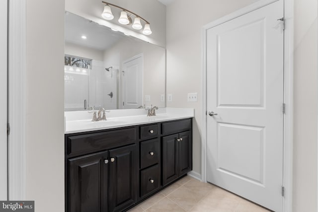 bathroom with walk in shower, vanity, and tile patterned floors