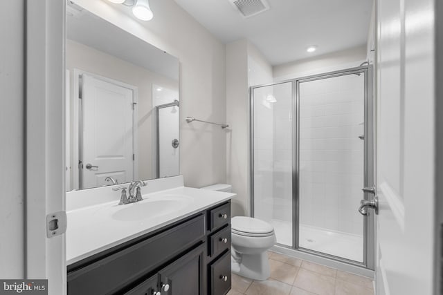 bathroom with toilet, walk in shower, vanity, and tile patterned flooring