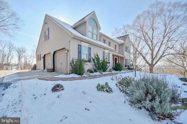 view of snow covered exterior featuring a garage