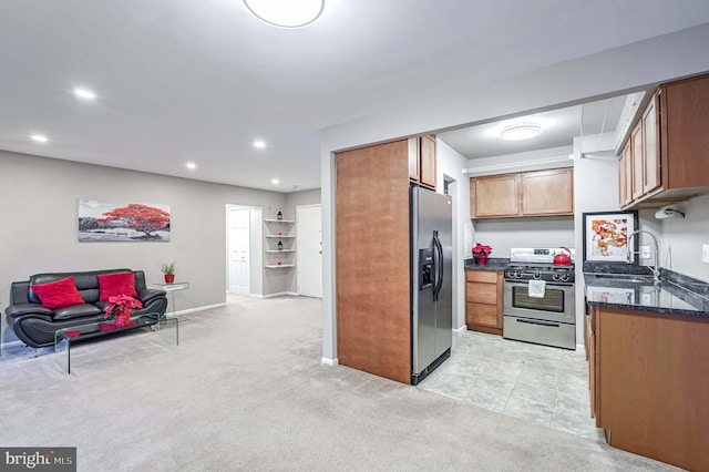 kitchen featuring dark stone countertops, stainless steel appliances, light colored carpet, and sink