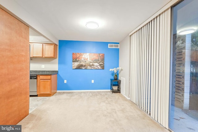 kitchen with dishwasher and light colored carpet