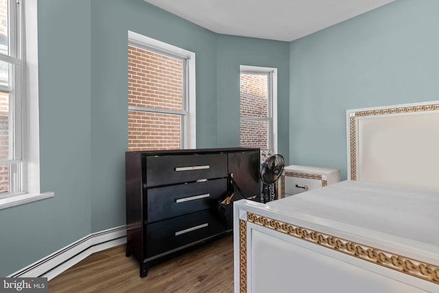 bedroom featuring baseboard heating and dark wood-type flooring