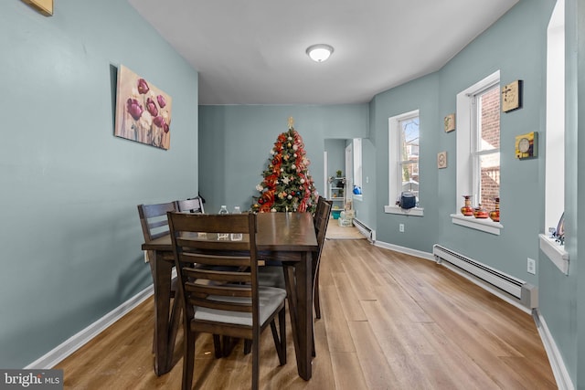 dining room with light hardwood / wood-style floors and baseboard heating