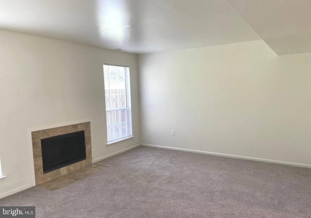 unfurnished living room with carpet floors and a fireplace