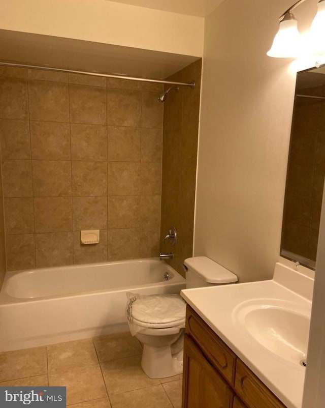 full bathroom featuring tiled shower / bath, tile patterned floors, vanity, and toilet