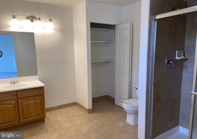 bathroom featuring an enclosed shower, vanity, toilet, and tile patterned flooring