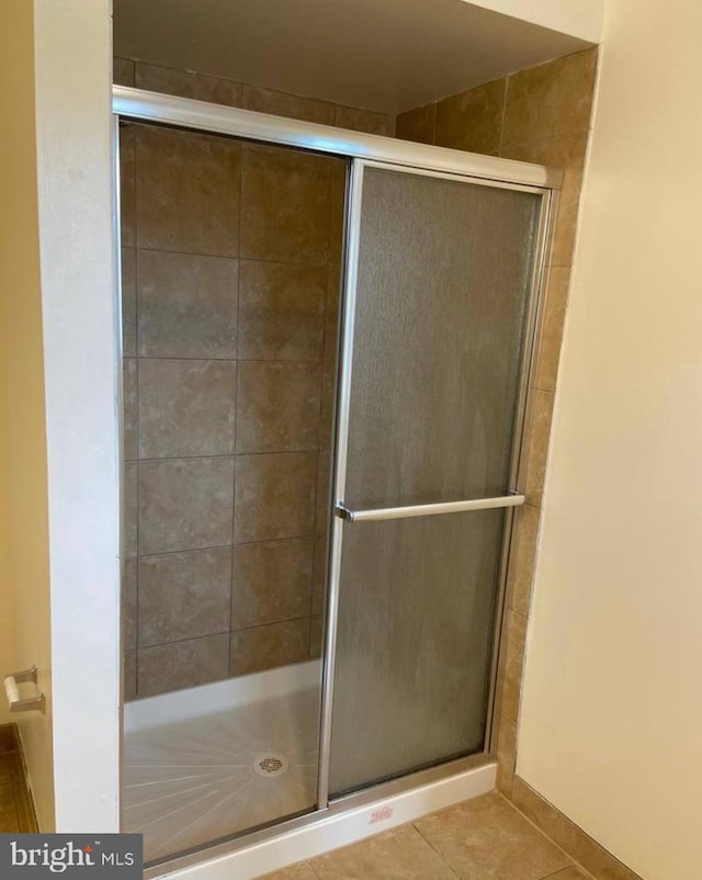 bathroom with tile patterned floors and a shower with shower door