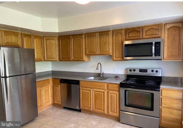 kitchen with sink, light tile patterned flooring, and stainless steel appliances