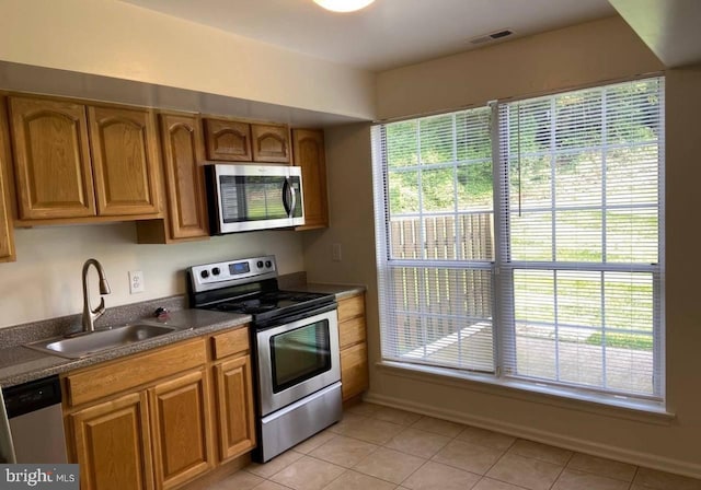 kitchen featuring light tile patterned floors, stainless steel appliances, and sink