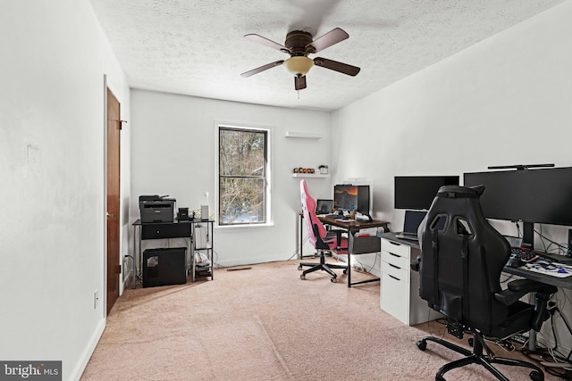 office area with carpet, ceiling fan, and a textured ceiling